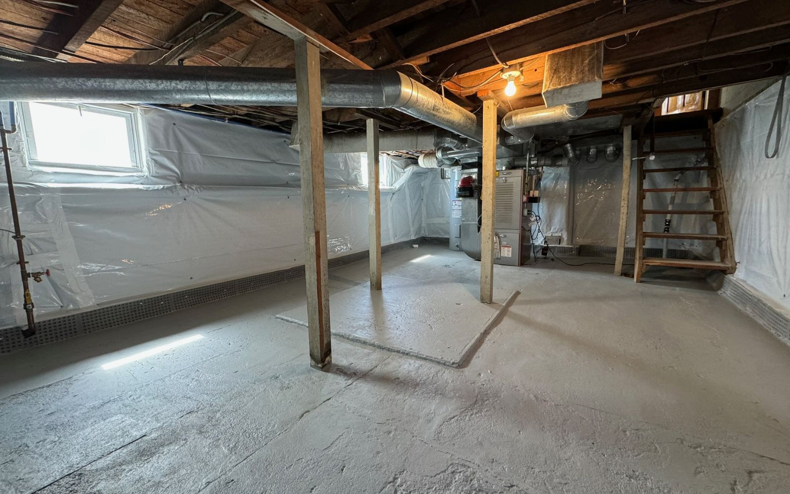user-inserted Basement with concrete floor, vapor barrier installed, and exposed support beams.